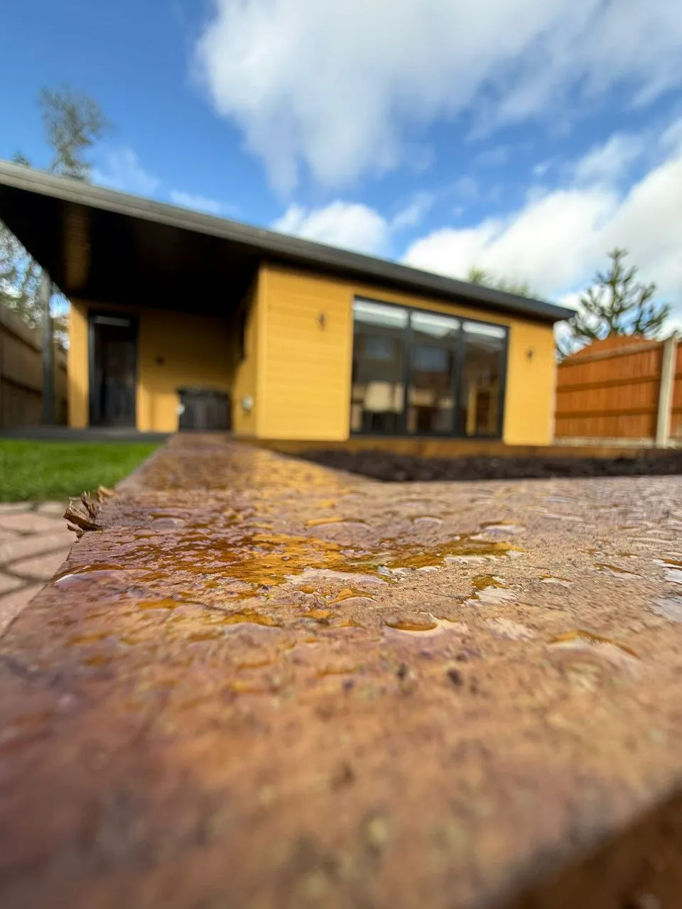 Yellow cedar annexe with bi-fold doors after rain