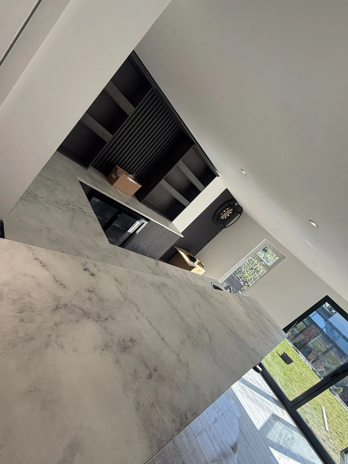 Custom bar marble worktop with L-shaped counter and integrated glass fridge
