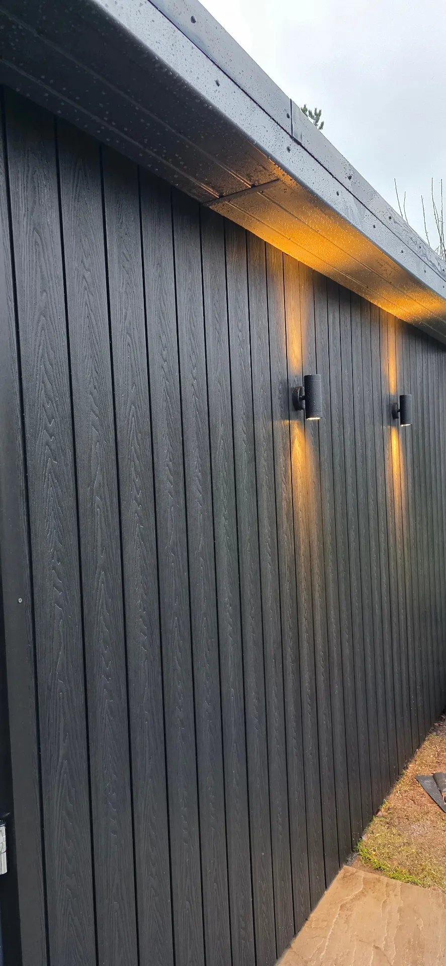 Annexe with charcoal composite cladding and external lighting