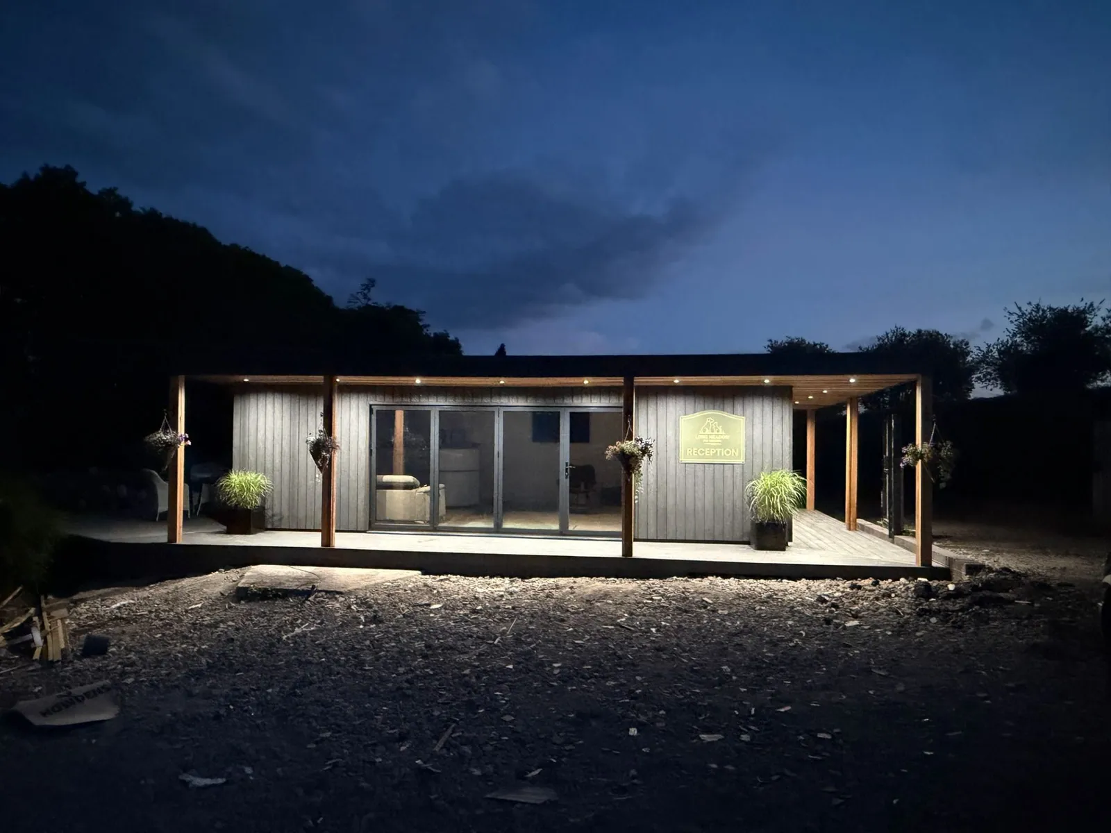 Completed cedar-clad garden building with bifold doors at twilight, built by LouMil