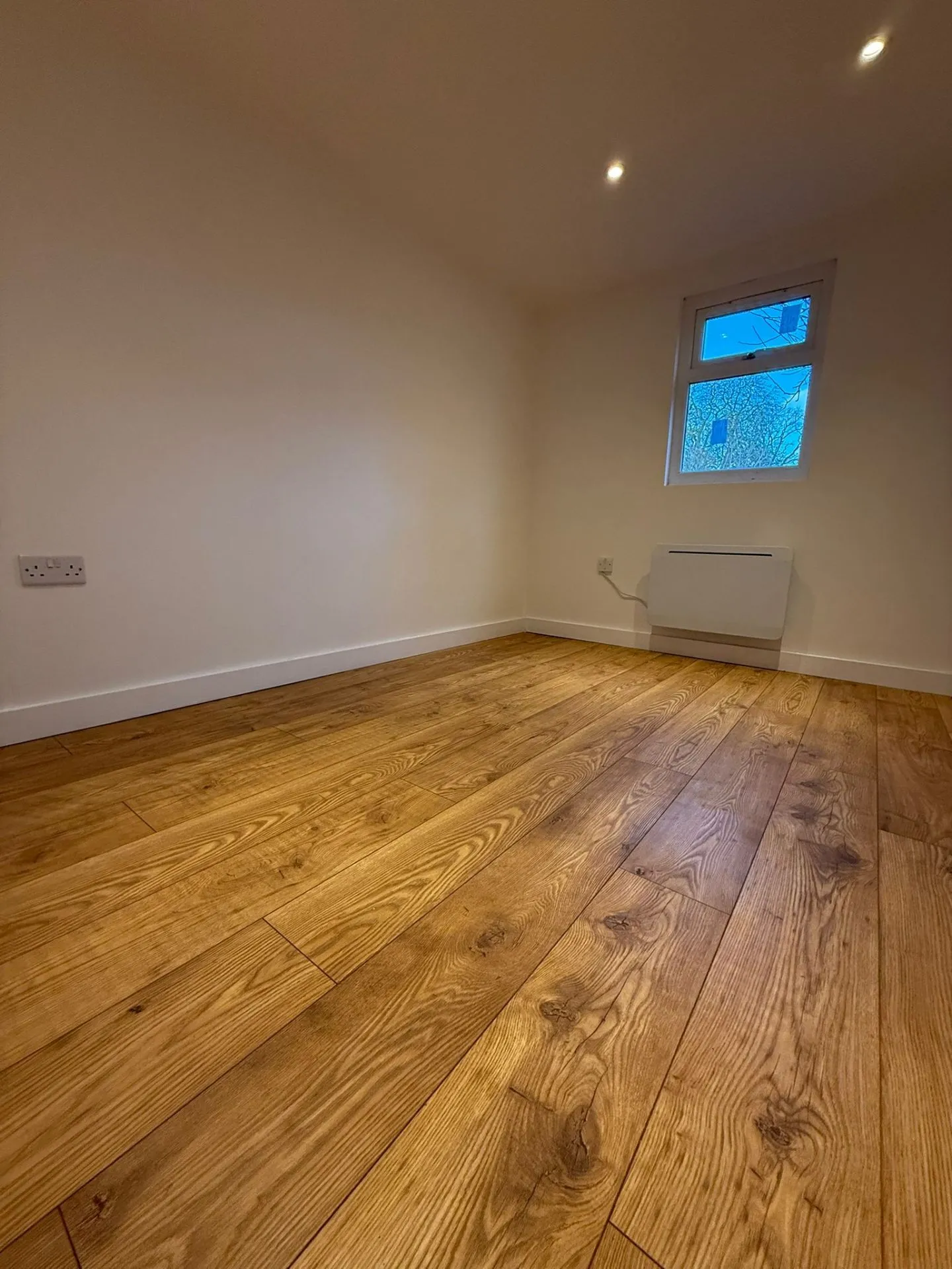 Annexe bedroom with oak flooring and panel heater